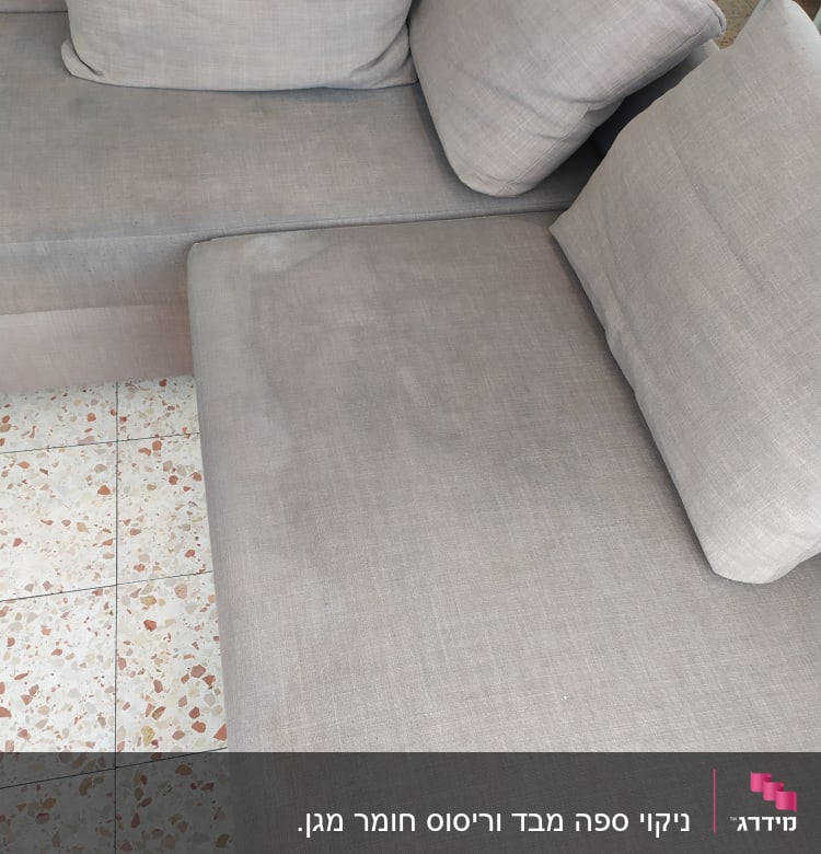 ספה אפורה עם כריות על רצפת אריחים